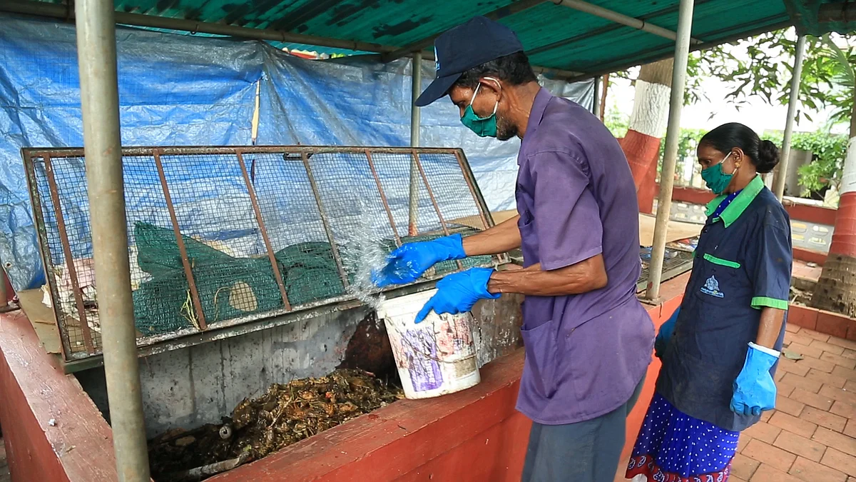 Workers from Sampoorn(e)arth treat a compost pit. 