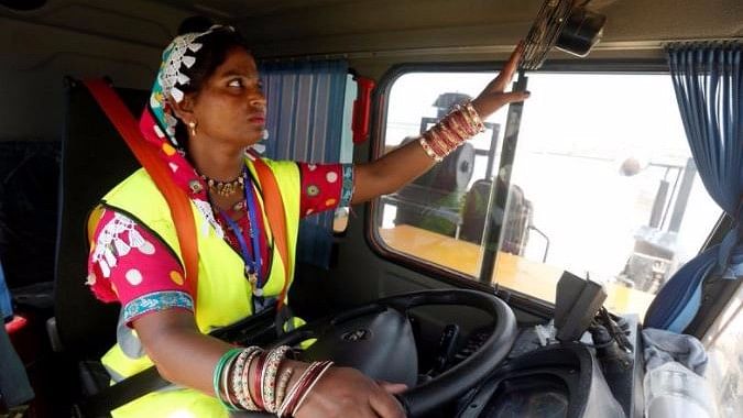 Gulaban, a 25-year old mother of three, adjusts a fan before driving a 60-tonne truck, during a training session of the Female Dump Truck Driver Programme in Pakistan.