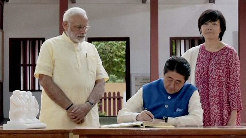 

 Prime Minister Narendra Modi looks on as Japanese Prime Minister Shinzo Abe signs the Visitors Book at Gandhi Ashram in Ahmedabad on Wednesday.