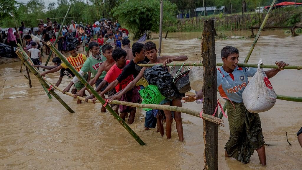 Rohingya refugees use a makeshift footbridge near Balukhali refugee camp
