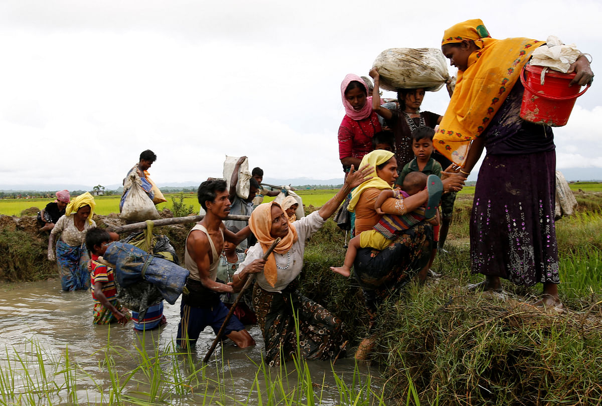 A group of Rohingya refugees cross a canal after travelling over the Bangladesh-Myanmar border in Teknaf, Bangladesh.