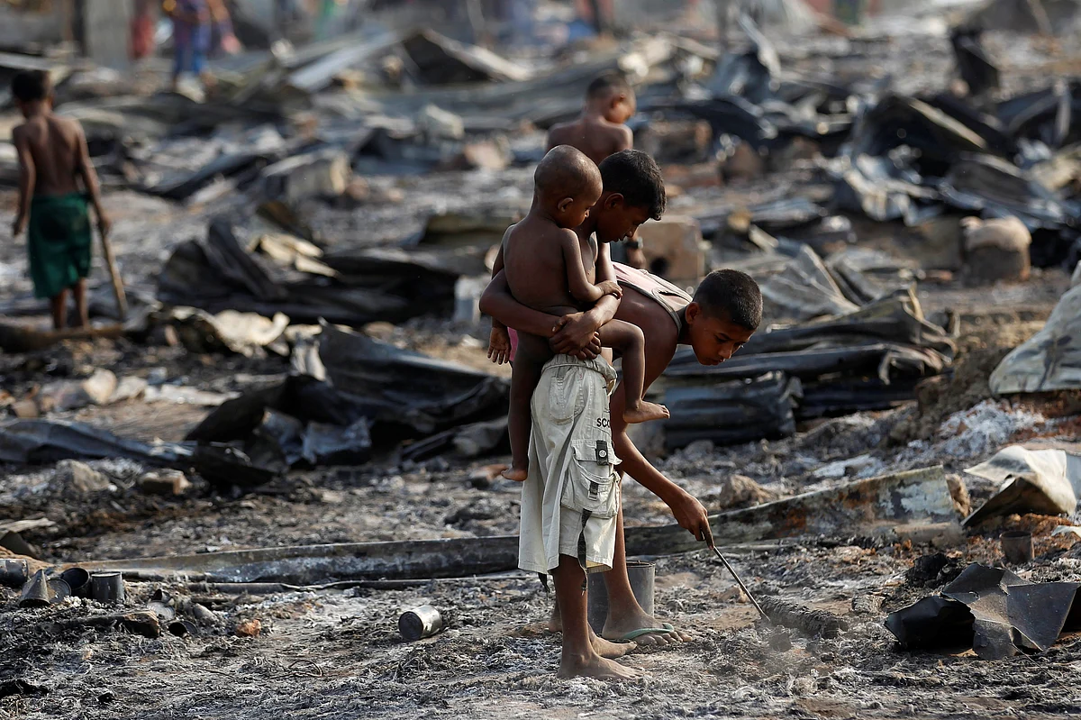 Boys search for useful items among the ashes of burnt houses after fire destroyed shelters at a camp for internally displaced Rohingya Muslims in the western Rakhine State near Sittwe, Myanmar