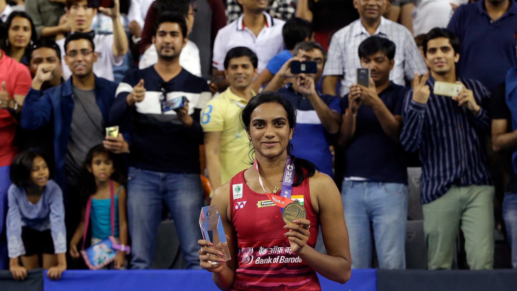 India’s Pusarla V. Sindhu poses with a gold and trophy during the awards ceremony after winning against Japan’s Nozomi Okuhara during women’s single final match at the Korea Open Badminton in Seoul