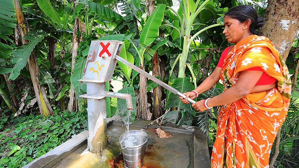 

A woman pumps up water from a tubewell in West Bengal despite the red cross that signifies that there is an unacceptable level of arsenic in the water.