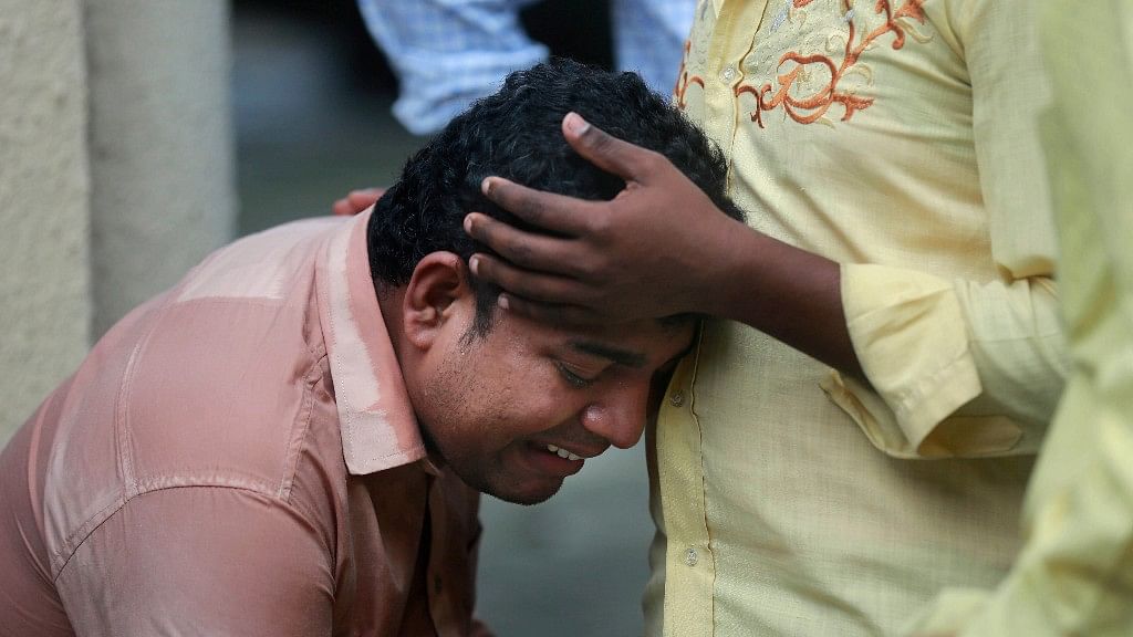 A man mourns outside a morgue for a relative killed in the Elphinstone bridge stampede.