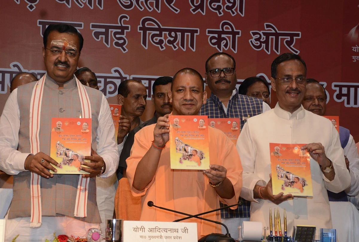 CM Yogi Adityanath along with deputy chief ministers Keshav Prasad Maurya and Dinesh Sharma, launch a book on the completion of six months, in Lucknow on 19 September 2017.