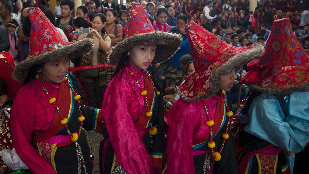 Exile Tibetan students in traditional costumes wait to perform a dance during an event marking the 57th anniversary of the formation of the Tibetan parliament-in-exile, at Tsuglakhang temple in Dharmsala.