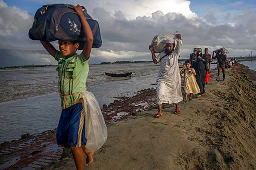 Newly arrived Rohingya Muslims, who crossed over from Myanmar into Bangladesh, walk towards the nearest refugee camp at Teknaf, Bangladesh.