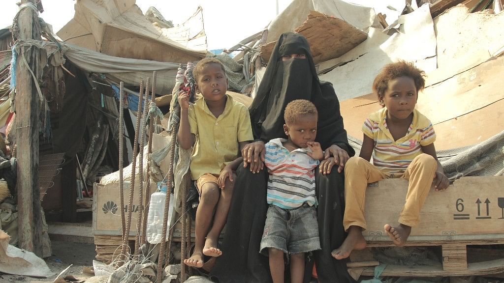 A displaced mother with her children next to their living place, Aden, Yemen, 6 August 2016.