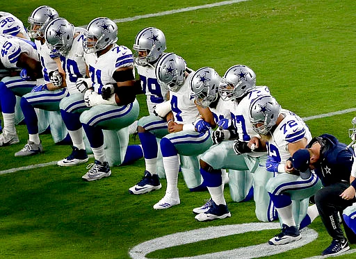 The Dallas Cowboys take a knee prior to the national anthem prior to an NFL football game against the Arizona Cardinals on Monday, 25 September 2017, in Arizona. 