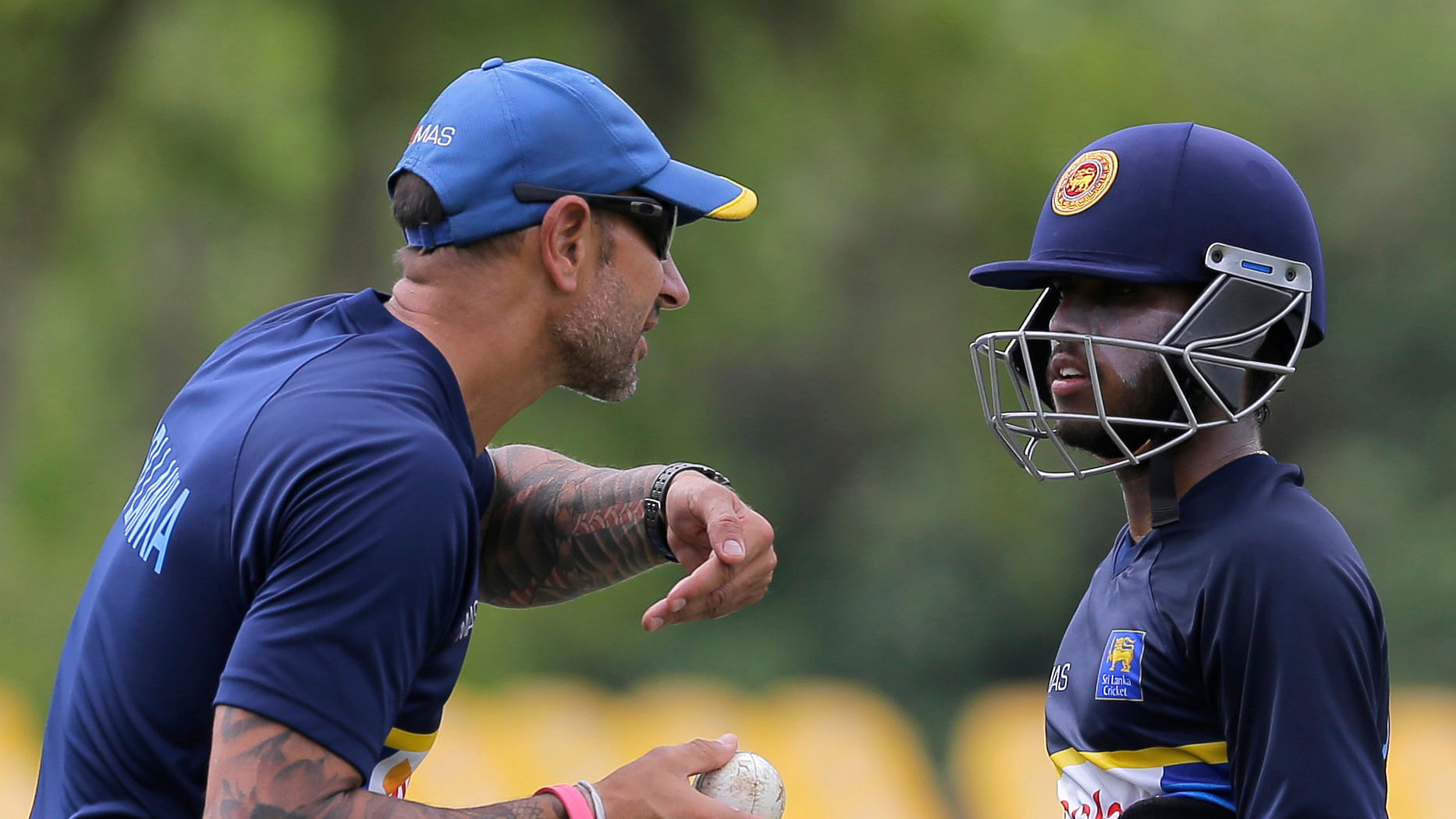 Sri Lankan cricket team coach Nic Pothas gestures as he talks to batsman Kusal Mendis during a practice session