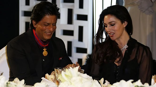 SRK and Monica Belluucci share a table at an event. 