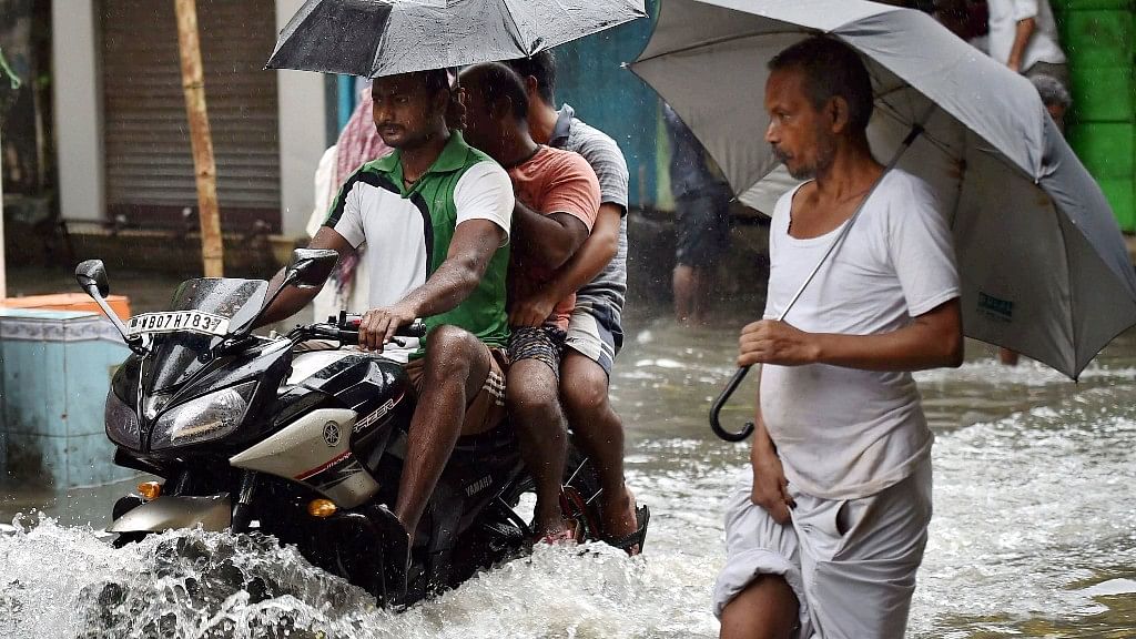 People wade through a waterlogged street in Kolkata on Monday.