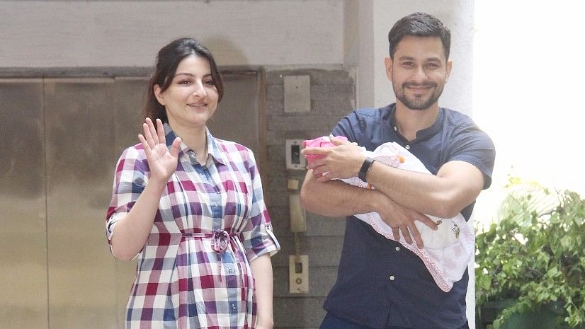 Soha Ali Khan waves to the camera as she steps out with her newborn daughter and husband, Kunal Kemmu.&nbsp;