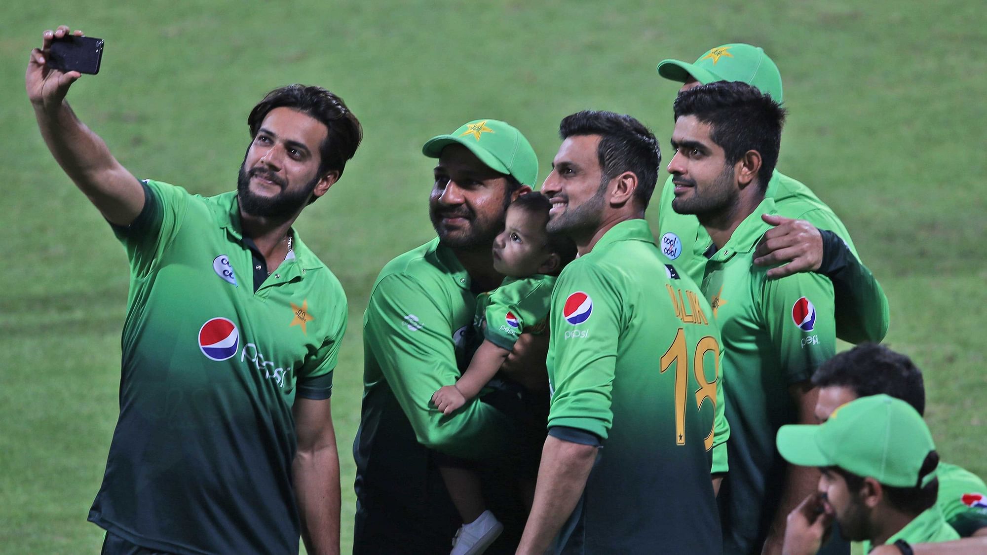 Pakistan’s Sarfaraz Ahmed holds his child while taking selfie with his teammates after they beat Sri Lanka in fifth ODI