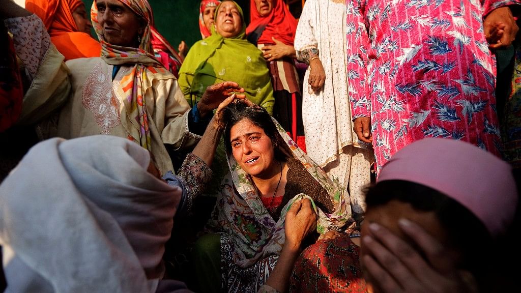 Women console a relative of Yasmeena, a woman who according to local media was killed by unidentified gunmen in Pulwama district, during her funeral in Khonmoh, south of Srinagar.
