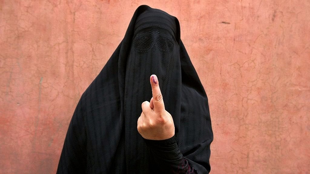 A veiled Muslim woman shows her ink-marked finger after voting outside a polling station in Doda district, north of Jammu.