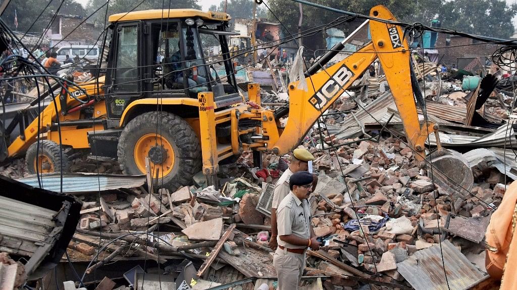 A Delhi Development Authority bulldozer carrying out demolition work at Kathputli Colony in the presence of police security in New Delhi on Monday.