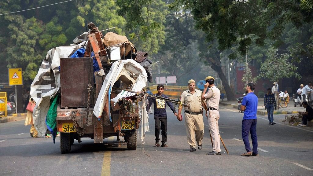 Police monitor as a truck is loaded with materials after evacuation following an NGT order to free Jantar Mantar off protestors, in New Delhi on Monday morning.&nbsp;
