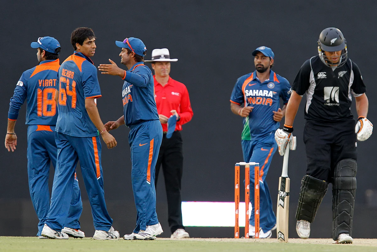Ashish Nehra celebrates a wicket with his teammates.