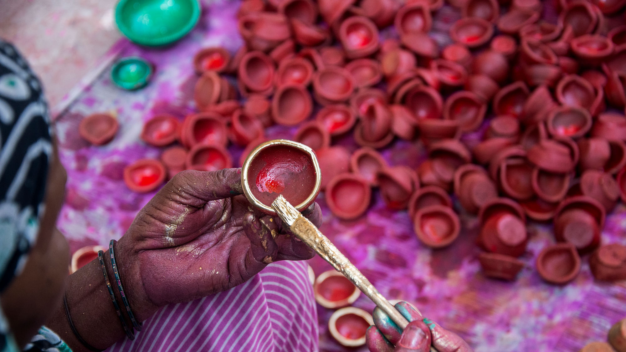 

A woman potter painting <i>diyas</i> for the upcoming diwali festival.