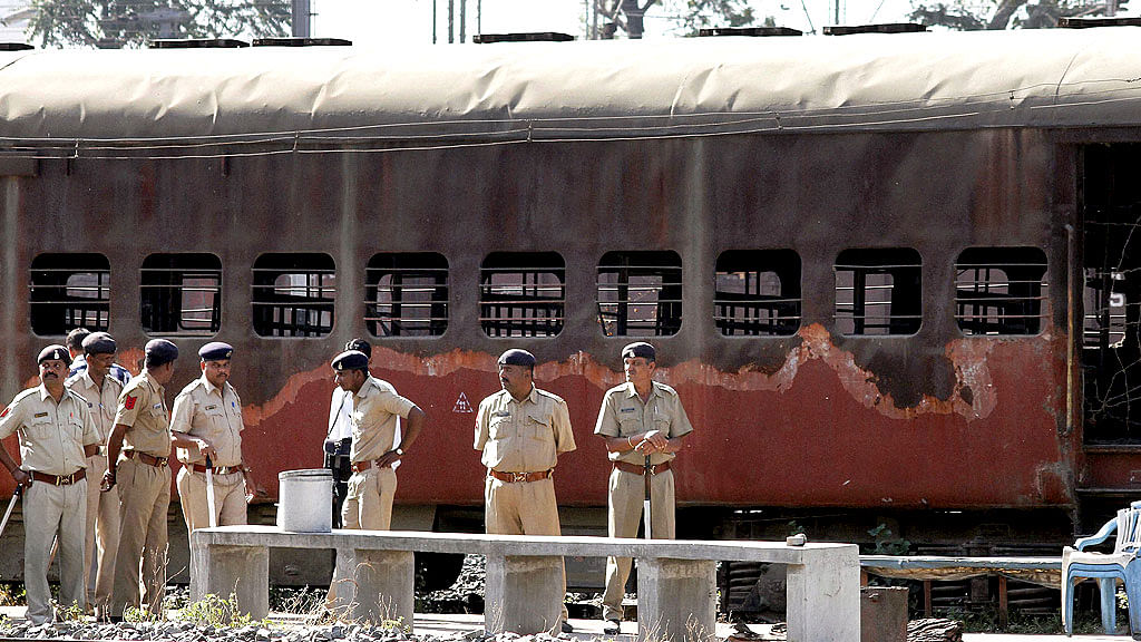 Police guard a train coach that was set ablaze in Godhra in 2002.&nbsp;
