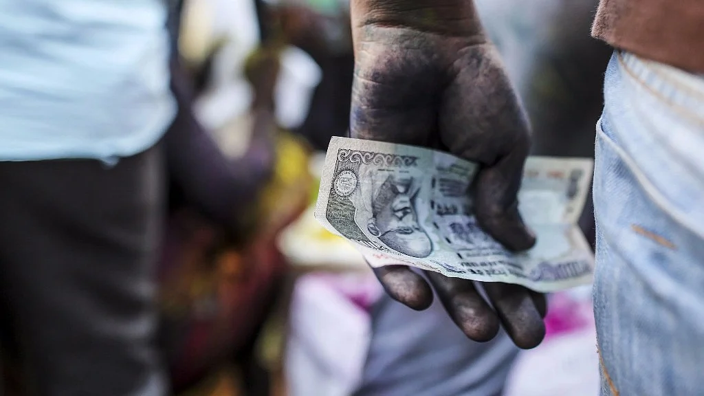 A vendor holds an Indian one hundred rupee banknote at a market stall in Mumbai on 11 March 2017. 