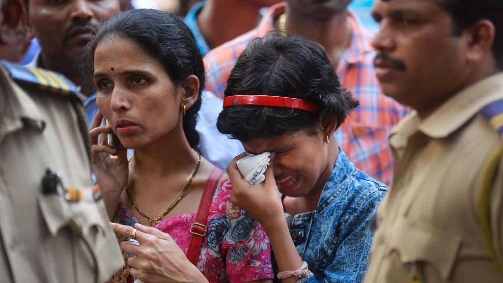 A family mourns outside a morgue for relatives killed in a pedestrian bridge stampede in Mumbai.
