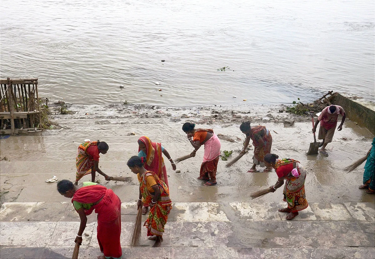 Employees of the Kolkata Municipal Corporation work to clean a ghat by the river Ganga after the completion of immersion of Durga puja idols, in Kolkata on Thursday