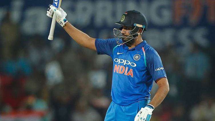 Rohit Sharma raises his bat after scoring a century.