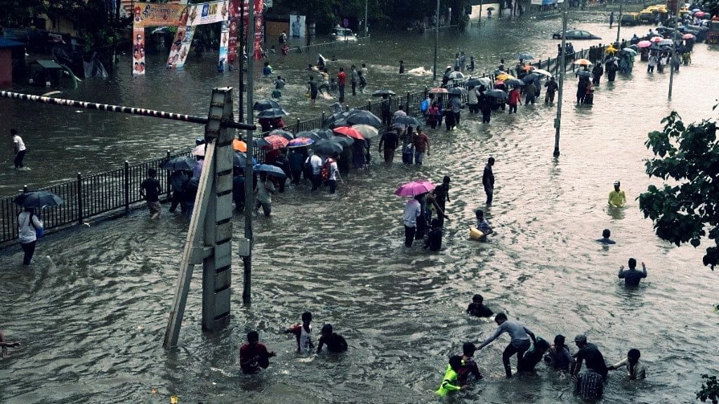People walk through a waterlogged street following heavy rains in Mumbai. Photo used for representational purpose.