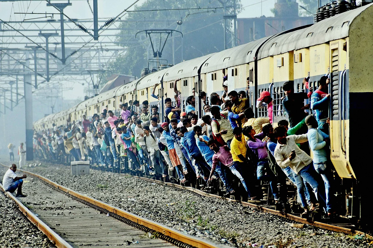 Passengers hang from the coaches of a train traveling to Patna for the Chhath puja. <i>(Photo: PTI) </i>