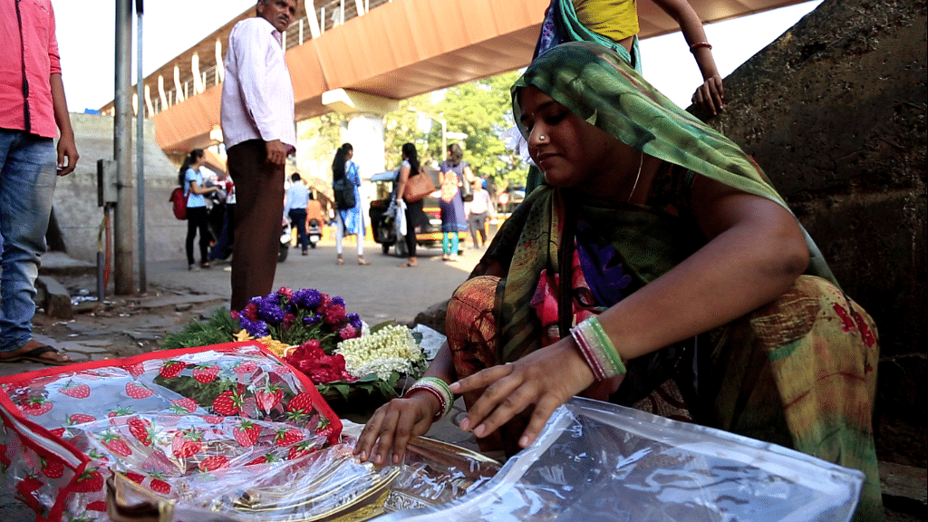 Sunita, a street vendor, sells her blanket covers outside the railway station.