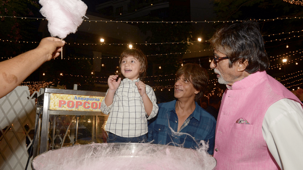 AbRam is delighted to finally see his cotton candy, as Shah Rukh Khan and Amitabh Bachchan look on amused.