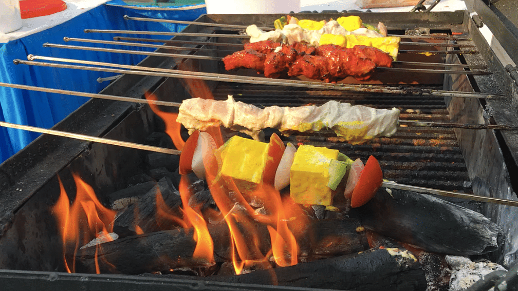 Sizzling BBQ kebabs cooking over a slow flame.&nbsp;