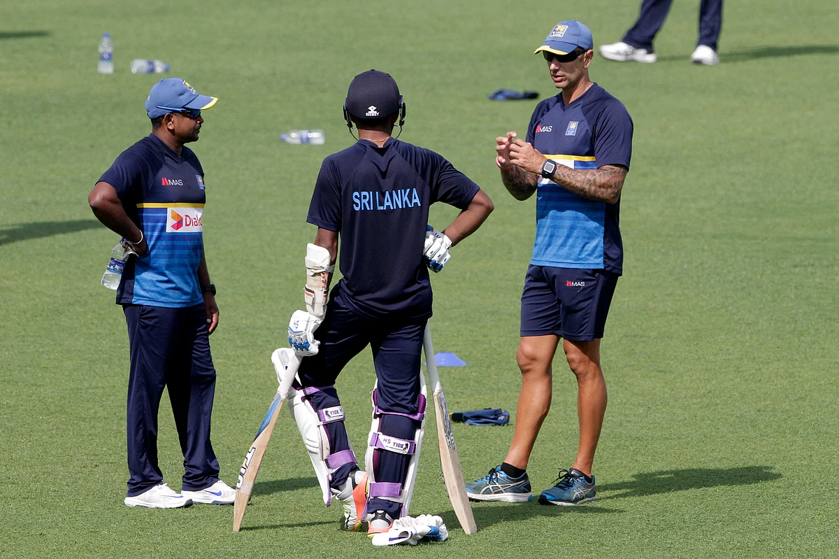 Sri Lanka coach Nic Pothas, R, talks with Rangana Herath, L and another player during practice session prior to their first test match at Eden Gardens in Kolkata, India, Tuesday, Nov. 14, 2017.