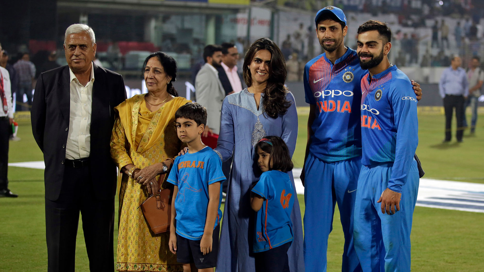 India’s Ashish Nehra, second right, pose with his family, to his left and captain Virat Kohli, right, as he bids farewell at the end of his last international match, during their first Twenty20 cricket match against New Zealand in New Delhi