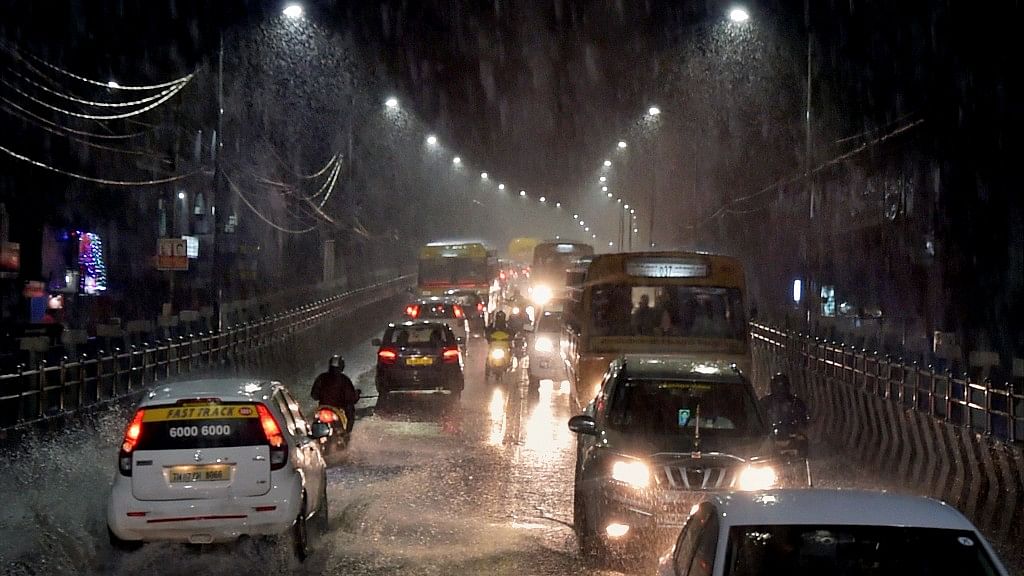 Vehicles move through a waterlogged road during heavy rain in Chennai.&nbsp;