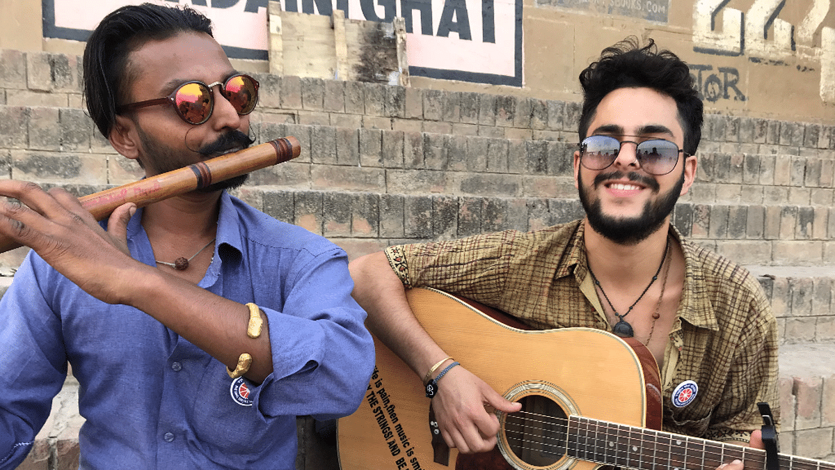 Anand and Roshan playing musical instruments at the Ghats in Varanasi.