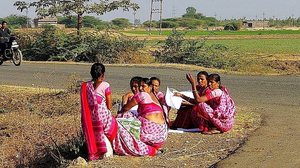 Village-level social workers confabulate and exchange notes near Limdi taluka in Dahod district.