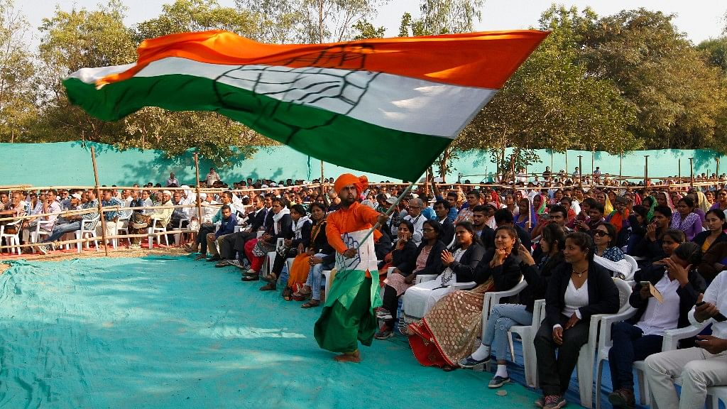A supporter waves a Congress flag at an election rally in Gujarat.