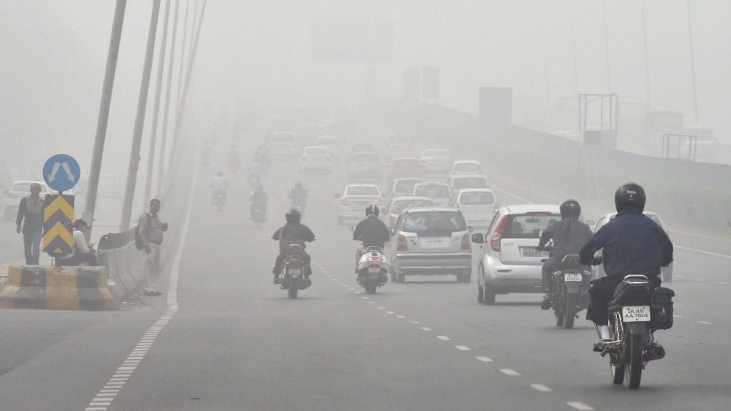 People commute through smog in New Delhi. 