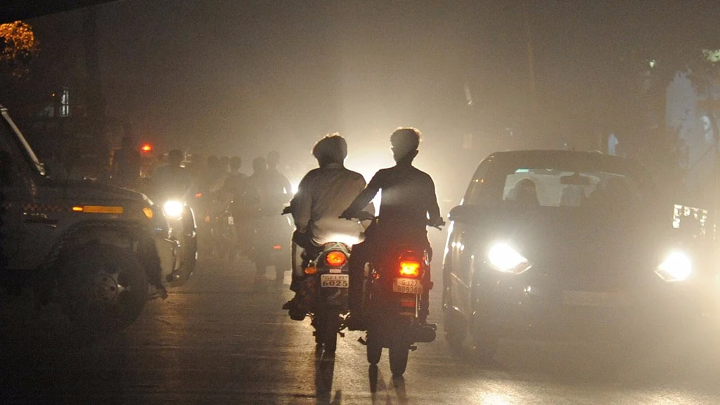 Traffic pushes through a thick layer of smog in Ahmedabad.