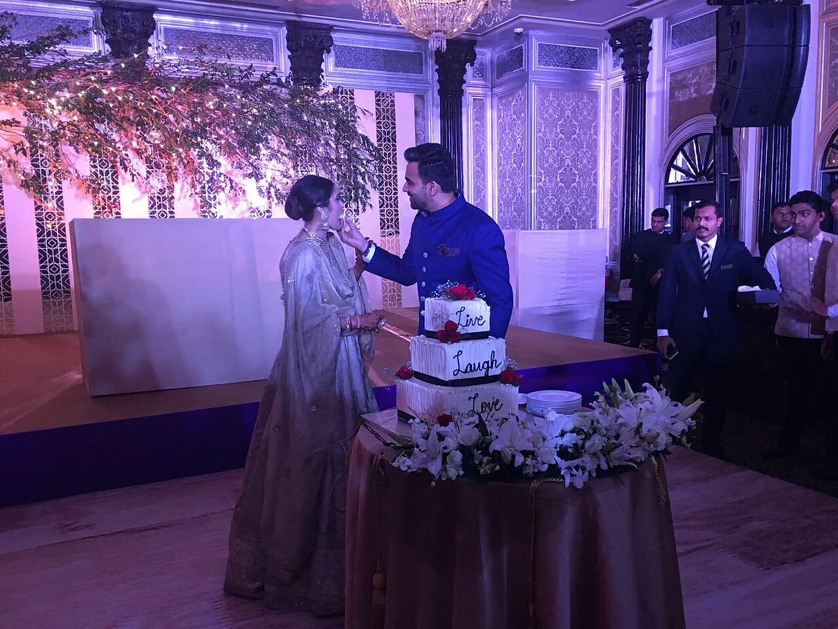 Zaheer and Sagarika feed each other the reception cake.