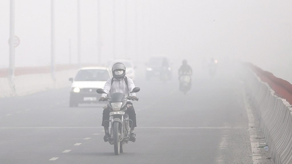 Motorists drive surrounded by smog in New Delhi.