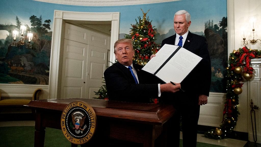 President Donald Trump, accompanied by Vice President Mike Pence, holds up a signed proclamation recognising Jerusalem as the capital of Israel in the Diplomatic Reception Room of the White House on 6 December.