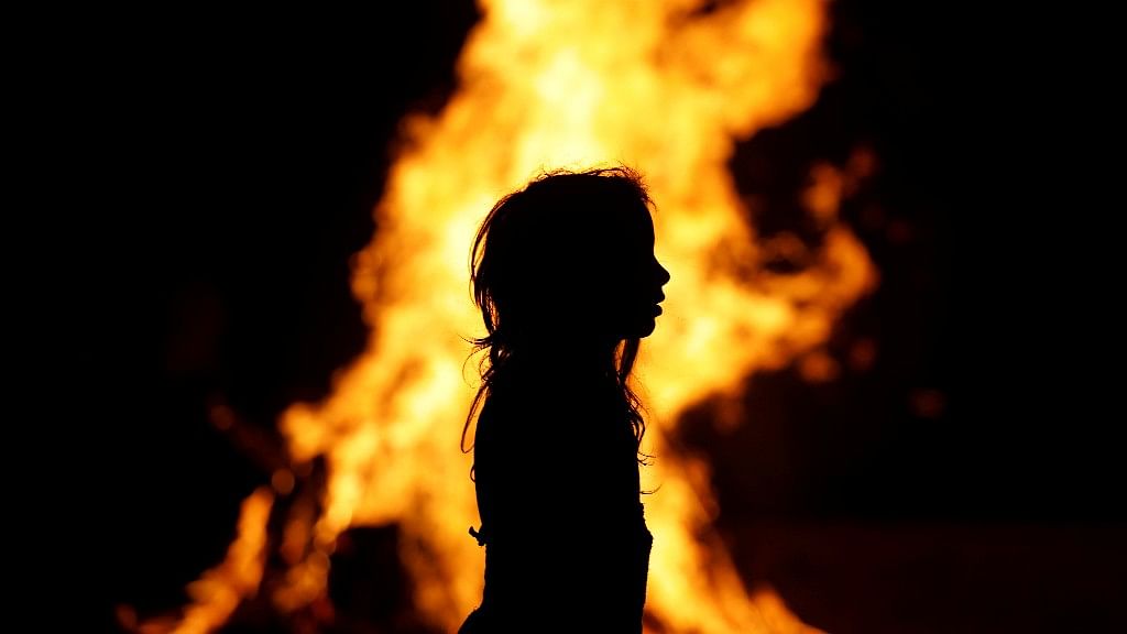 An Ultra-Orthodox Jewish girl stands around a bonfire as she celebrates the Jewish holiday of Lag Ba’Omer in the city of Ashdod, Israel.