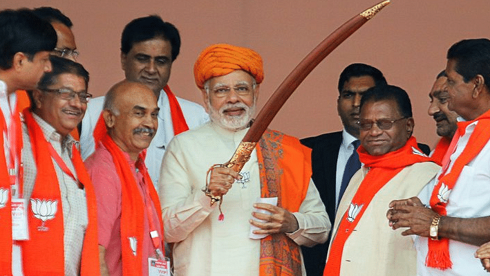 Prime Minister Narendra Modi being presented a sword by  supporters during an election campaign rally, at Dhandhuka village of Ahmedabad district on Wednesday, 6 December.