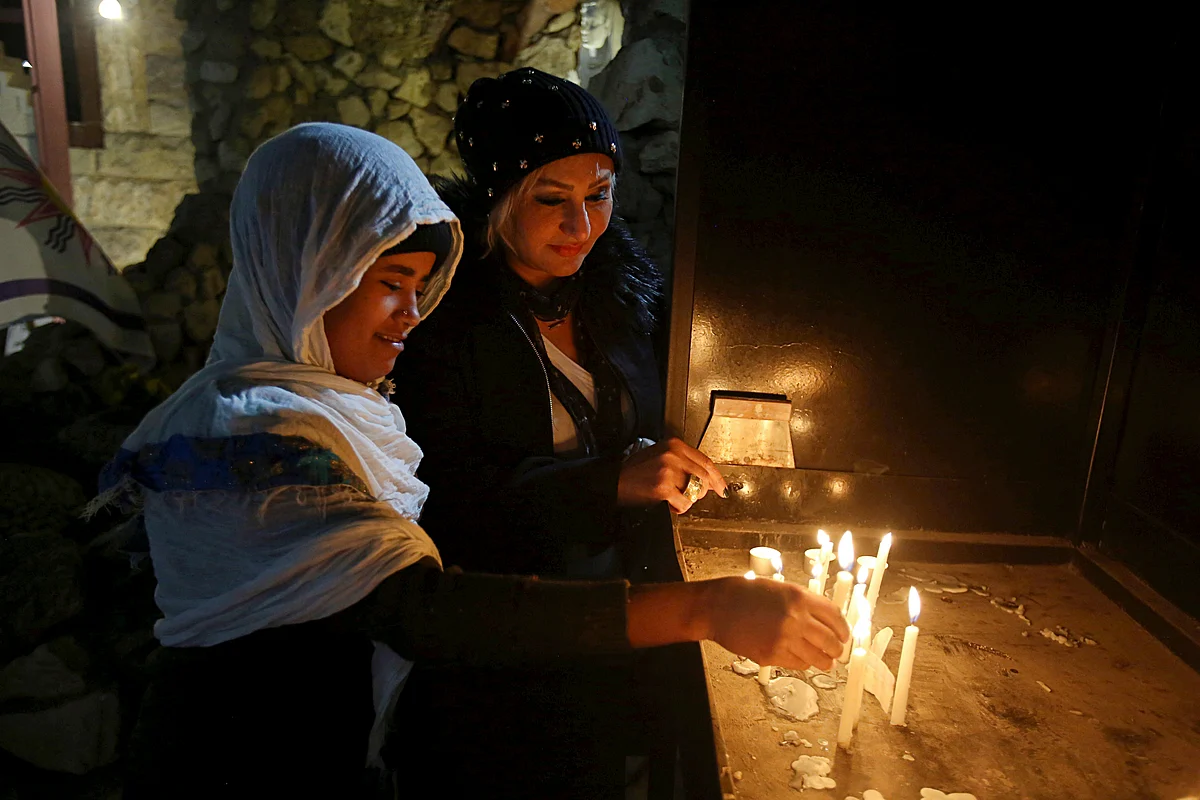 Iraqi Christians light candles after a Christmas Eve Mass in St. Joseph’s Church in Baghdad, Iraq, 24 December 2017
