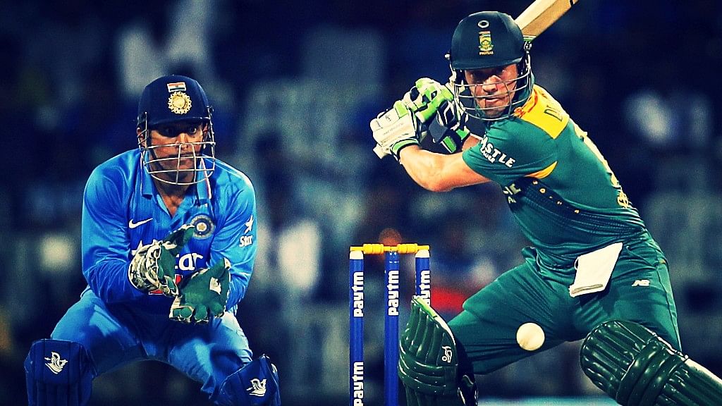 AB de Villiers plays a shot during an ODI as MS Dhoni looks on.